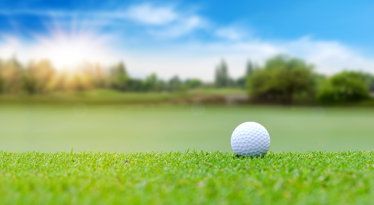 White Golf ball on green course to be shot on blurred beautiful